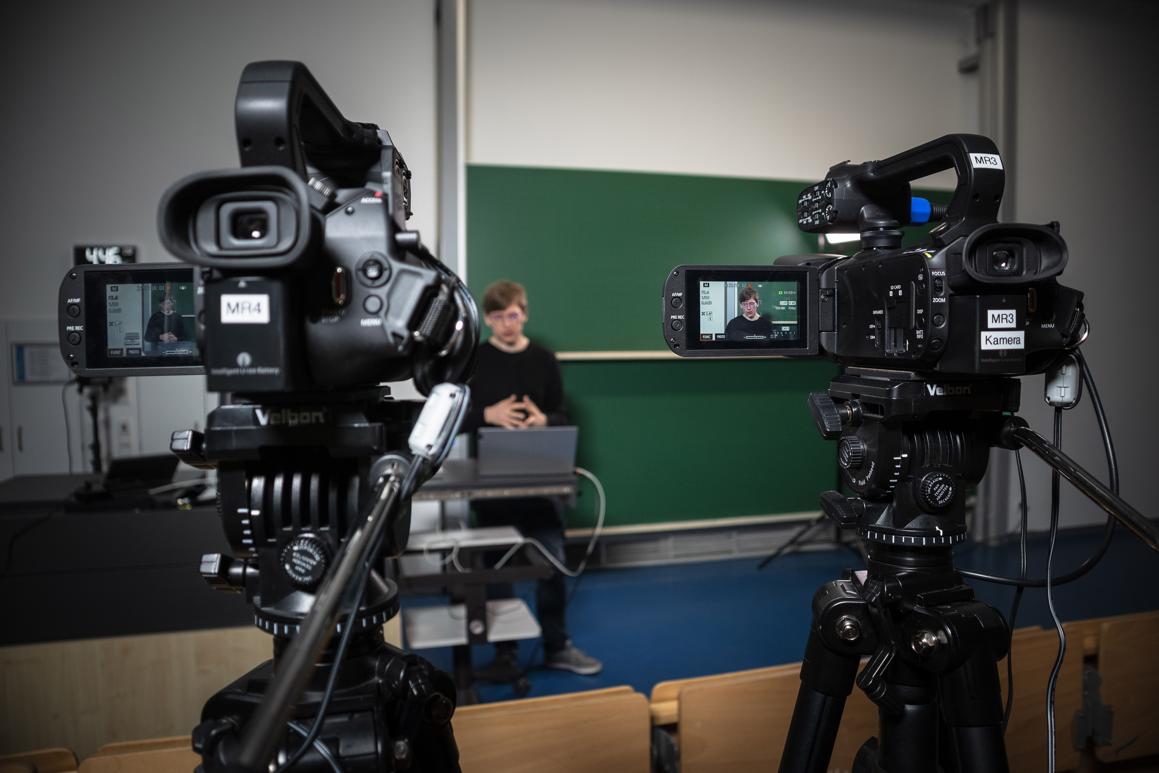 Foto einer Kamera mit aufgeklappten Display, welches den Referent im Fokus zeigt